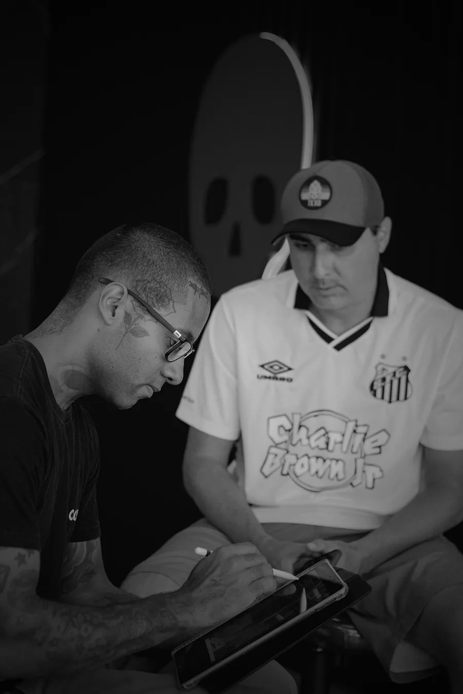 Felipe Carlos definindo a arte com o cliente no estúdio.