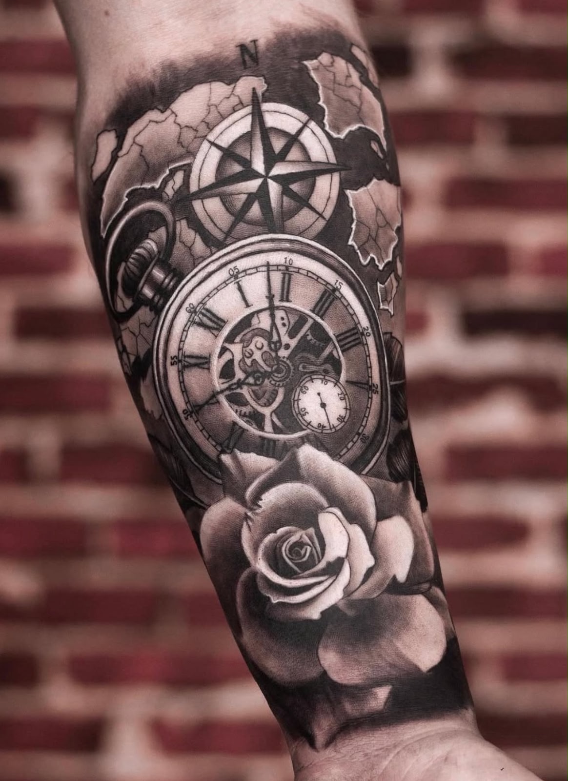Antebraço com rosa dos ventos, relógio antigo, mapa e rosa, realismo em preto e cinza por Felipe Carlos.