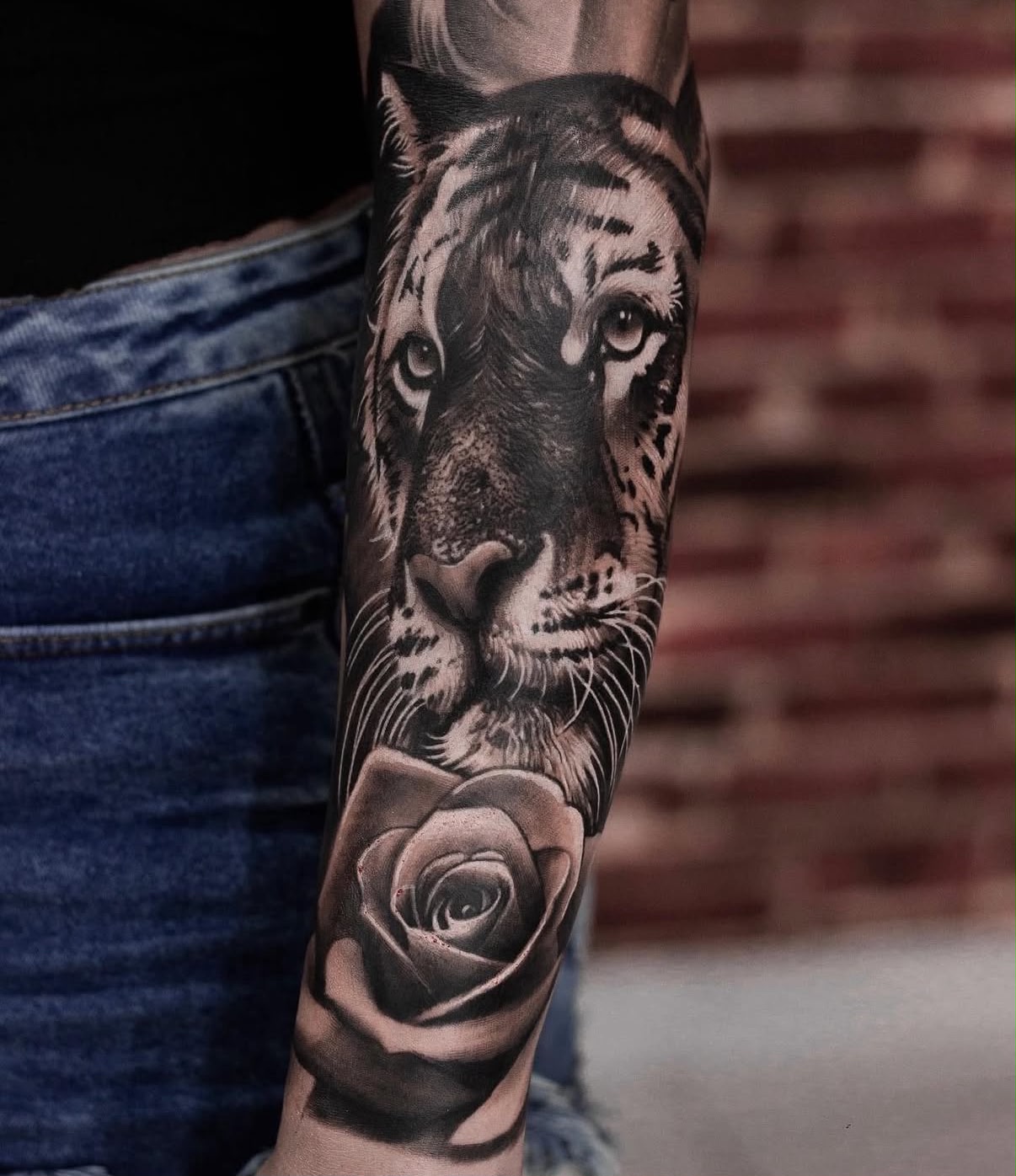 Antebraço com retrato de tigre e rosa em preto e cinza, realismo por Felipe Carlos.